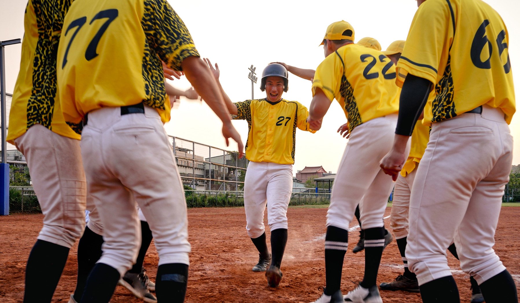 Youth baseball players celebrate a homerun, showcasing team unity enabled by efficient roster management software.